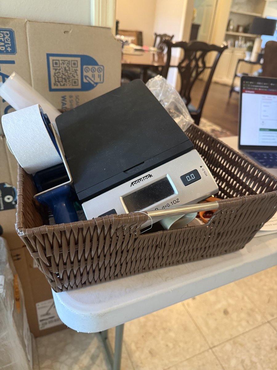 Supply bin with scale, tape gun, and packing tools
